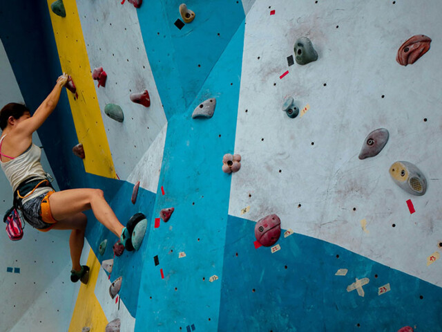 person climbing indoor rock wall without ropes or a belay, innovative portfolios perspectives