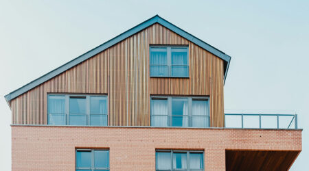 side of a house, the bottom half is sided with bricks and the top half is sided with skinny wooden panels, innovative portfolios perspectives