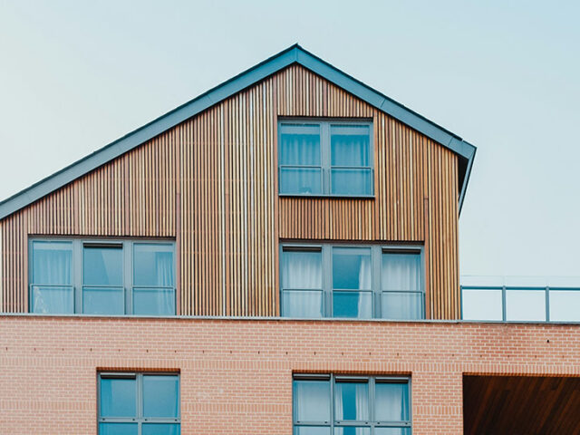 side of a house, the bottom half is sided with bricks and the top half is sided with skinny wooden panels, innovative portfolios perspectives