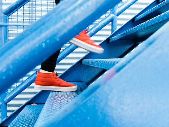 close-up of red sneakers going up a blue staircase, innovative portfolios perspectives