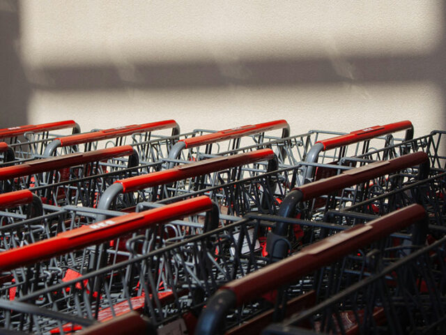 close up of shopping carts stacked up against a white wall