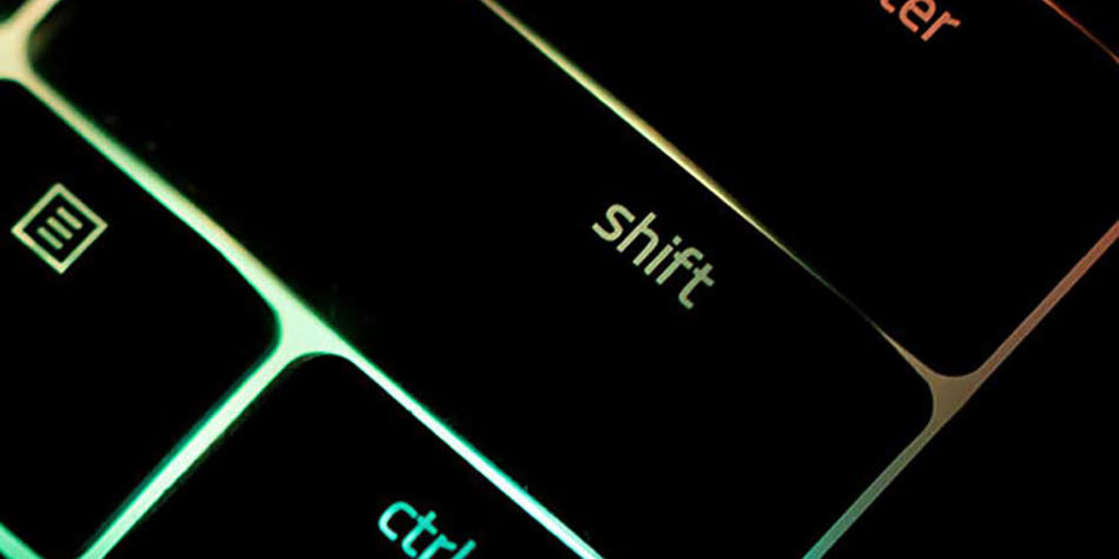 close-up of black shift key on keyboard with rainbow light showing underneath the keys, innovative portfolios perspectives