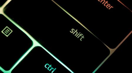 close-up of black shift key on keyboard with rainbow light shining behind the keyboard, innovative portfolios perspectives