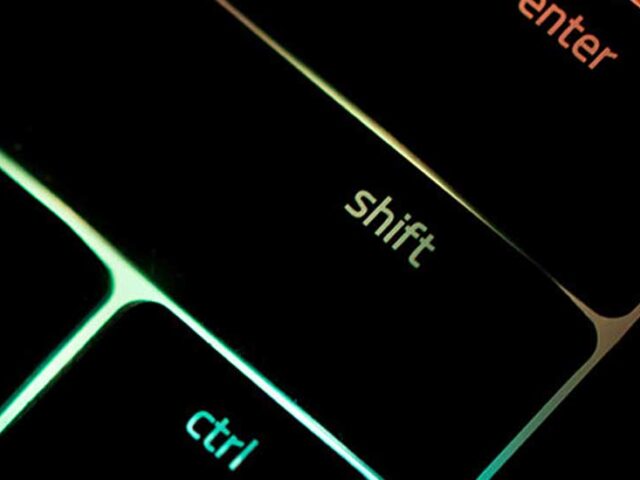 close-up of black shift key on keyboard with rainbow light shining behind the keyboard, innovative portfolios perspectives