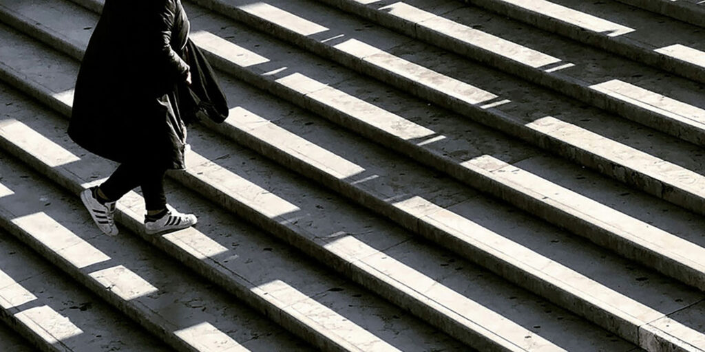 person walking up a stone staircase, innovative portfolios perspectives