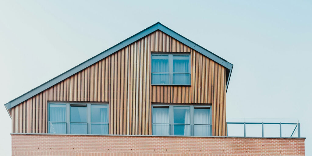 side of a house, the bottom half is sided with bricks and the top half is sided with skinny wooden panels, innovative portfolios perspectives